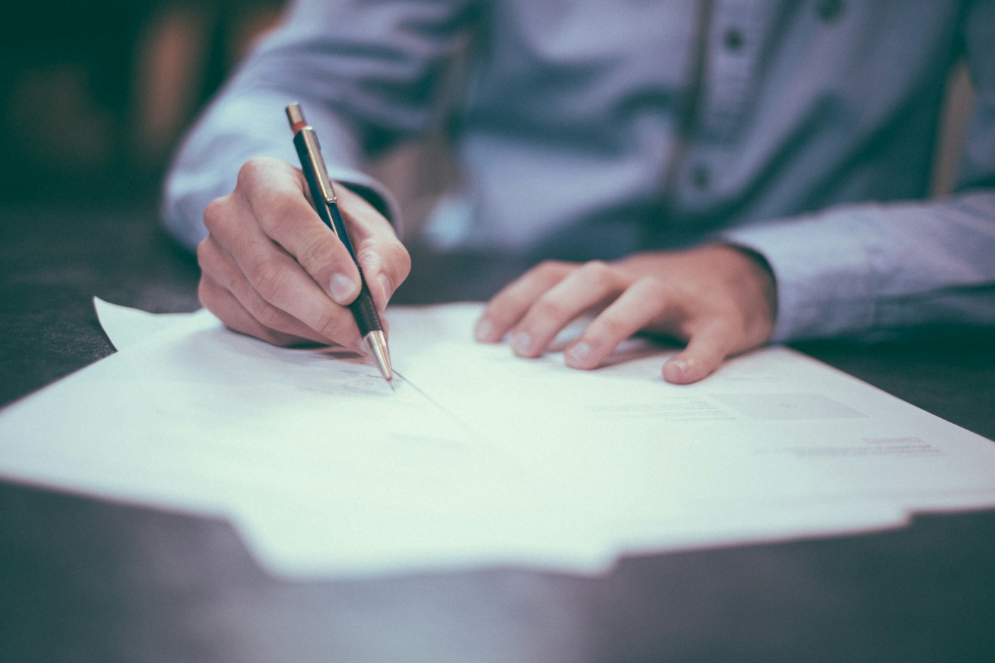 Professional reviewing and signing business documents at a desk